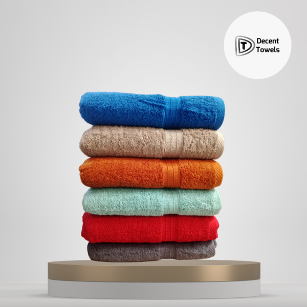 Stack of colorful cotton bath towels – Blue, Beige, Orange, Mint Green, Red, and Grey – from Decent Towels